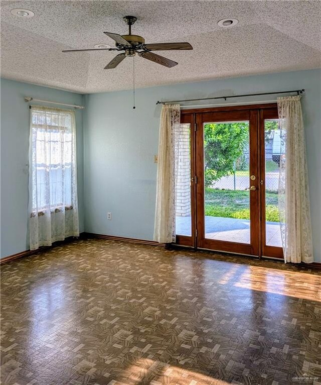 spare room with baseboards, a ceiling fan, a textured ceiling, and recessed lighting