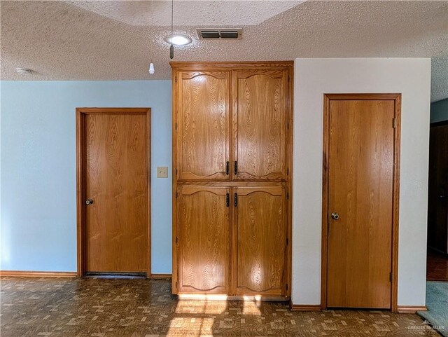 unfurnished bedroom featuring a textured ceiling and baseboards