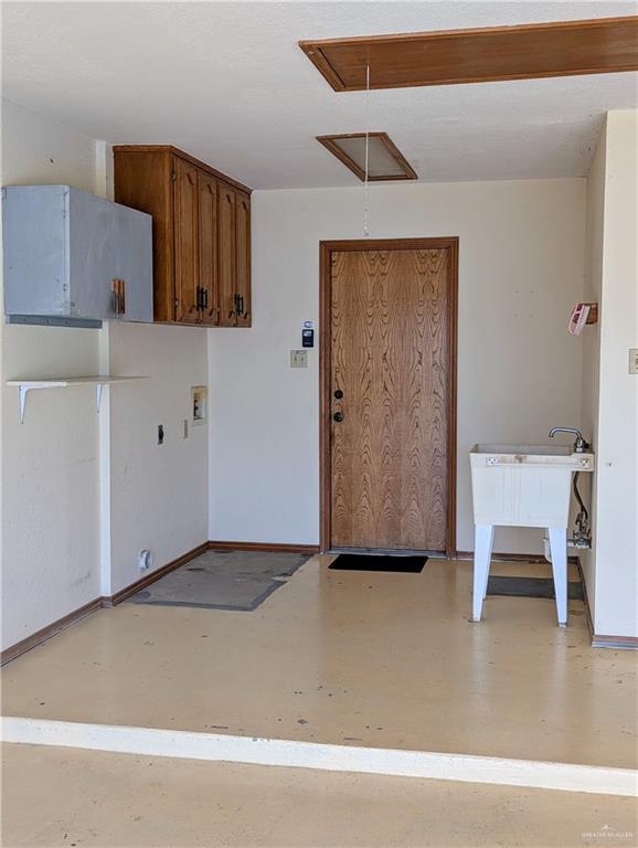 laundry area featuring attic access and baseboards