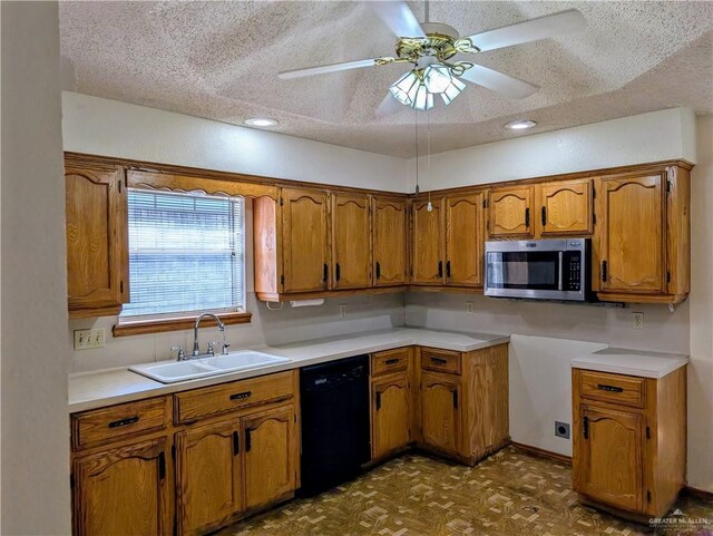 kitchen with stainless steel microwave, a sink, black dishwasher, brown cabinetry, and a textured ceiling