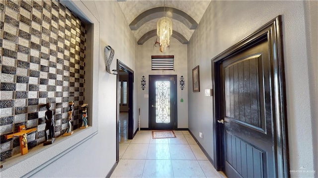 entryway featuring a notable chandelier, light tile patterned flooring, and brick ceiling