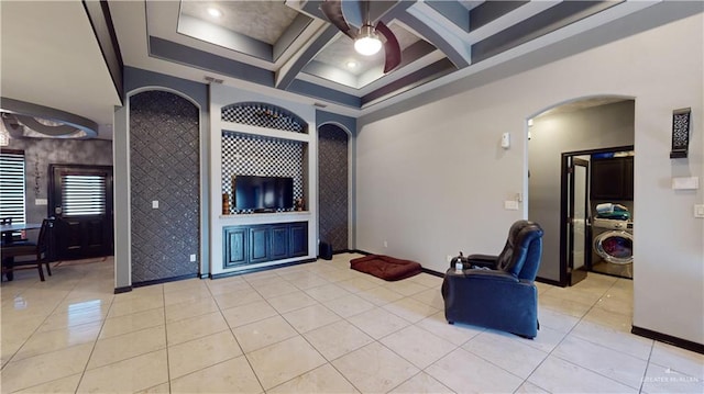 living area featuring washer / dryer, light tile patterned floors, beamed ceiling, and coffered ceiling