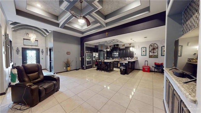 tiled living room featuring ceiling fan with notable chandelier and coffered ceiling