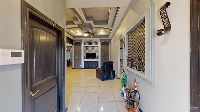 hallway with beamed ceiling, light tile patterned floors, and coffered ceiling