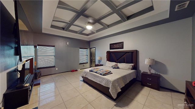 bedroom with beam ceiling, coffered ceiling, and light tile patterned flooring