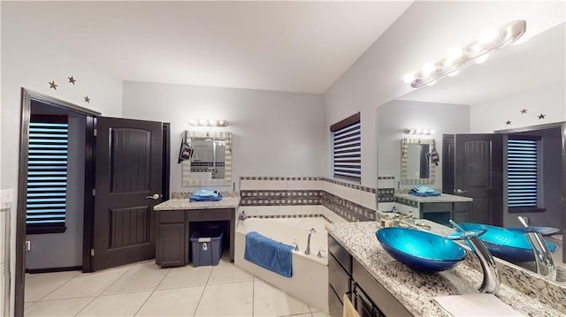 bathroom with tile patterned floors, a tub, and vanity