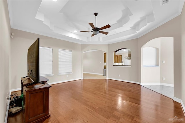 living room with crown molding, a raised ceiling, ceiling fan, and light hardwood / wood-style flooring