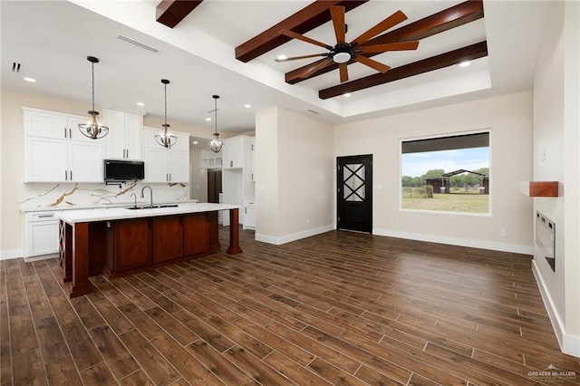 15439 E Davis Rd, Edinburg, TX 78542 - kitchen with black microwave, open floor plan, light countertops, dark wood finished floors, and beam ceiling