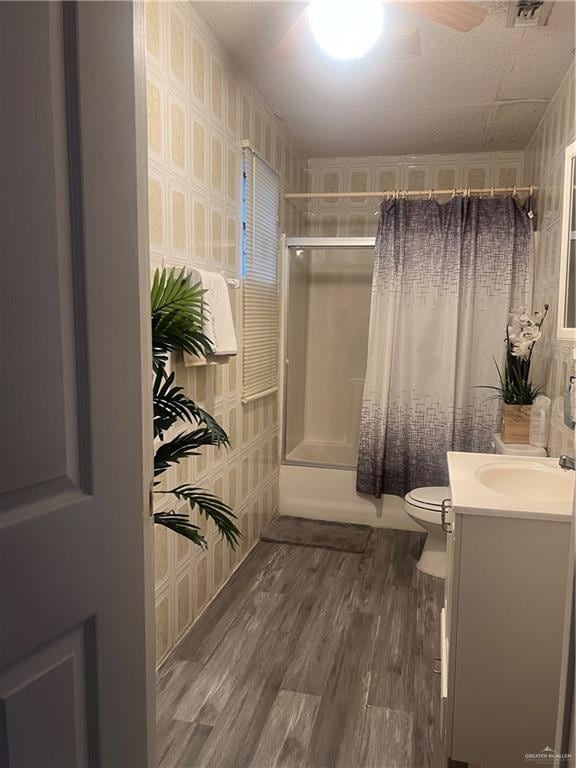 full bathroom with vanity, toilet, shower / bathtub combination with curtain, and hardwood / wood-style flooring