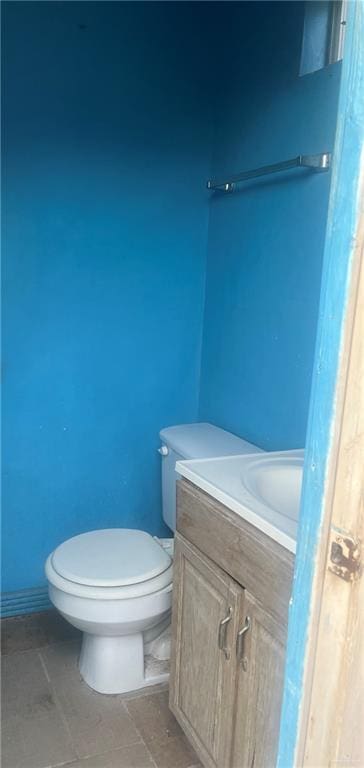 bathroom with tile patterned flooring, vanity, and toilet