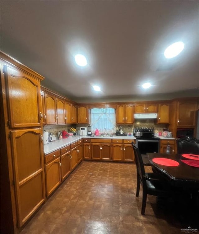 kitchen with electric range, sink, and tasteful backsplash