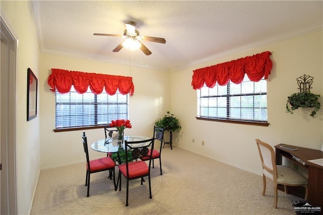 carpeted dining room featuring a wealth of natural light, crown molding, and ceiling fan