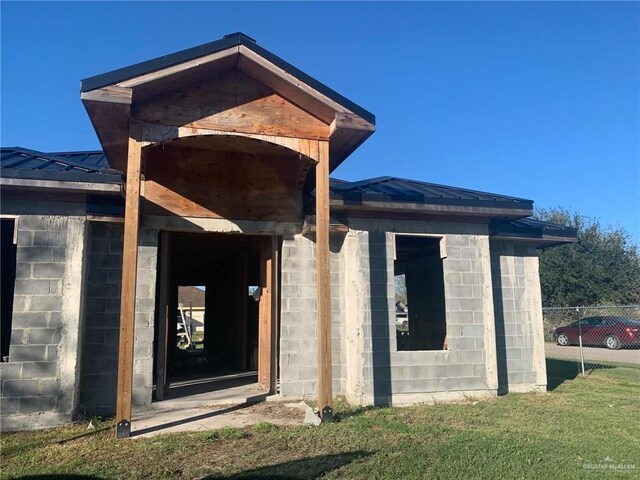 property entrance featuring a lawn