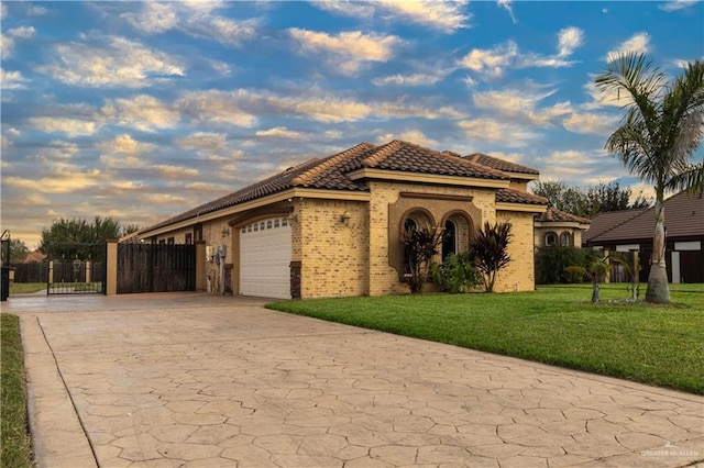 mediterranean / spanish house featuring a garage and a lawn