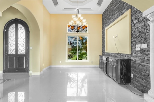 foyer featuring a tray ceiling, french doors, and a notable chandelier