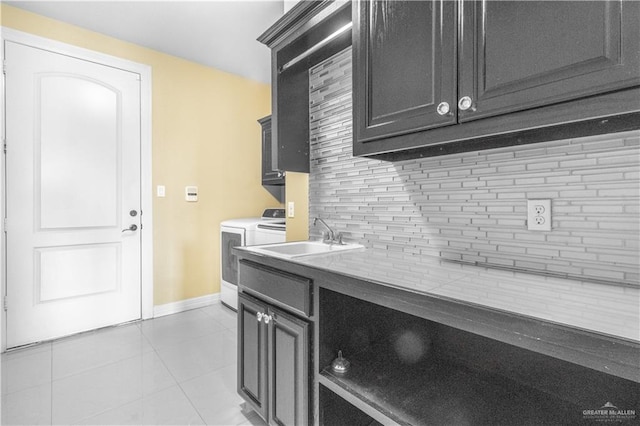 kitchen with tasteful backsplash, sink, light tile patterned flooring, and independent washer and dryer