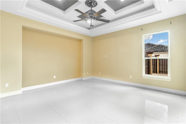 spare room with a tray ceiling, ceiling fan, and light tile patterned flooring