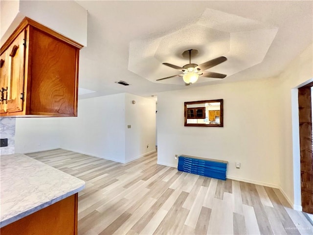 interior space featuring ceiling fan, light hardwood / wood-style flooring, and a textured ceiling