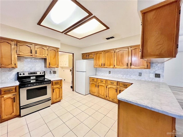 kitchen with backsplash, kitchen peninsula, stainless steel electric range, and white refrigerator