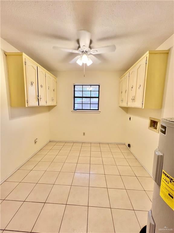 washroom with washer hookup, cabinets, a textured ceiling, and hookup for an electric dryer