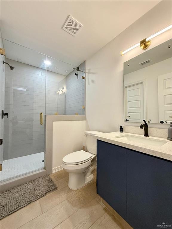 bathroom featuring an enclosed shower, vanity, and toilet