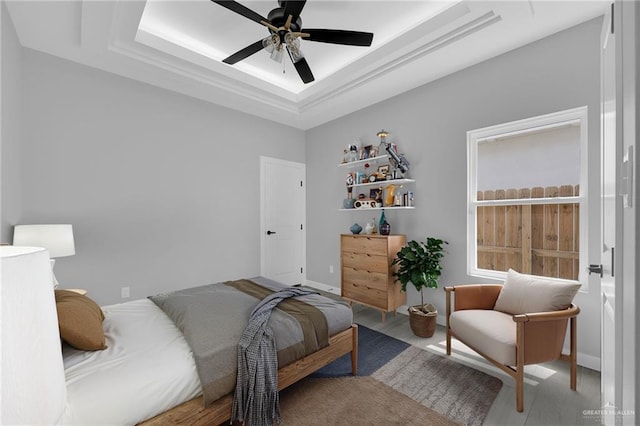 1104 Azalea Ave, Mission, TX 78573 - bedroom featuring a tray ceiling, wood finished floors, a ceiling fan, and baseboards