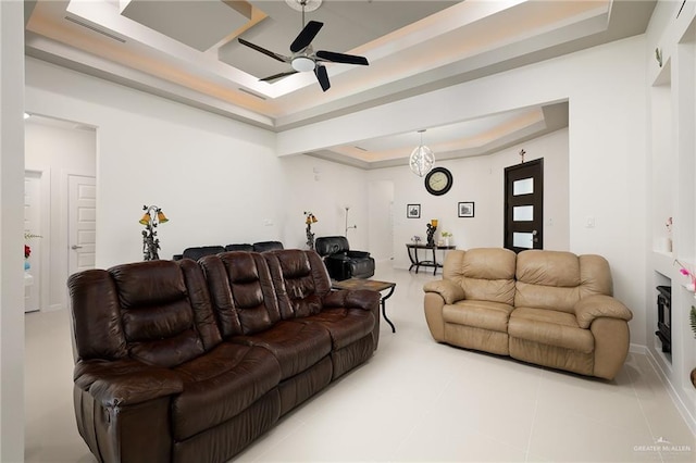living area with visible vents, tile patterned flooring, a ceiling fan, and a raised ceiling