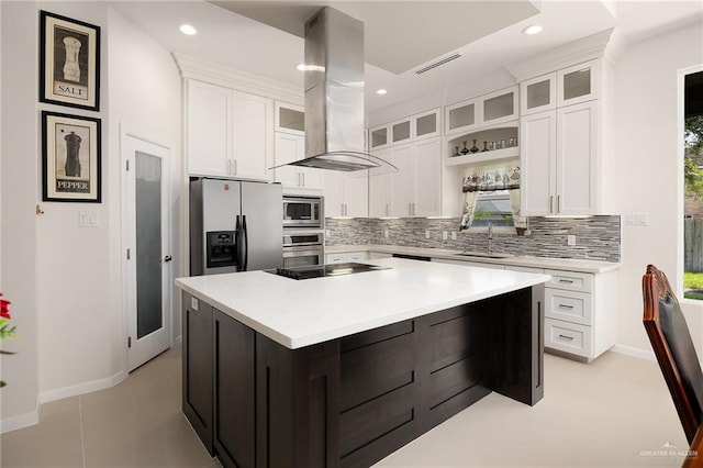 kitchen with a center island, appliances with stainless steel finishes, a sink, island range hood, and backsplash