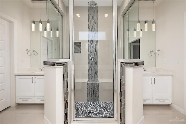 bathroom featuring a sink, a shower stall, and two vanities