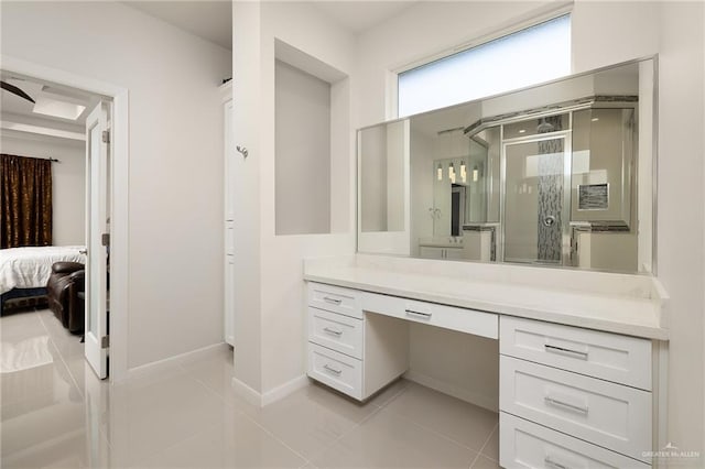 ensuite bathroom featuring a stall shower, vanity, tile patterned flooring, ensuite bath, and baseboards