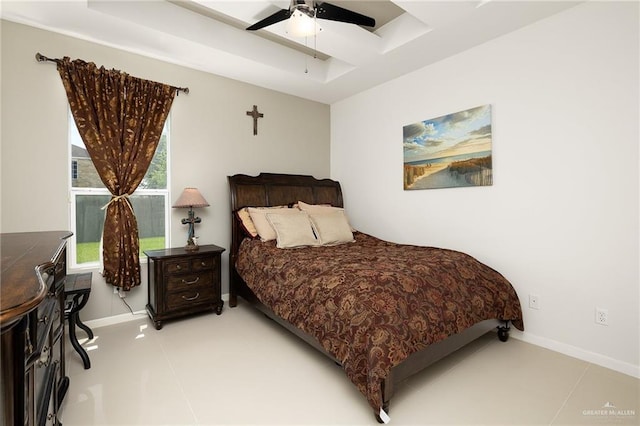bedroom featuring baseboards, ceiling fan, and a raised ceiling