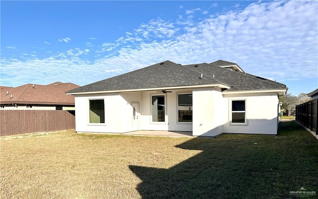 back of house featuring a lawn, ceiling fan, and a patio area