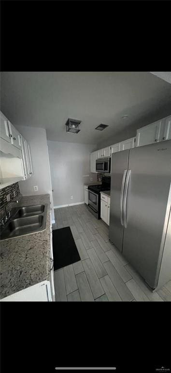 2201 S Jackson Rd Unit J11, Pharr, TX 78577 - kitchen with white cabinets, stainless steel appliances, light countertops, a sink, and wood finish floors