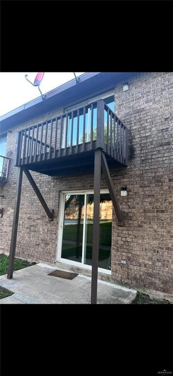 2201 S Jackson Rd Unit J11, Pharr, TX 78577 - view of side of home with brick siding, a balcony, and a patio