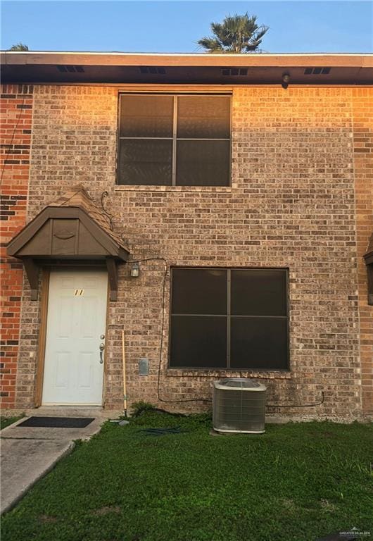 2201 S Jackson Rd Unit J11, Pharr, TX 78577 - view of front of house with central AC, a front lawn, and brick siding