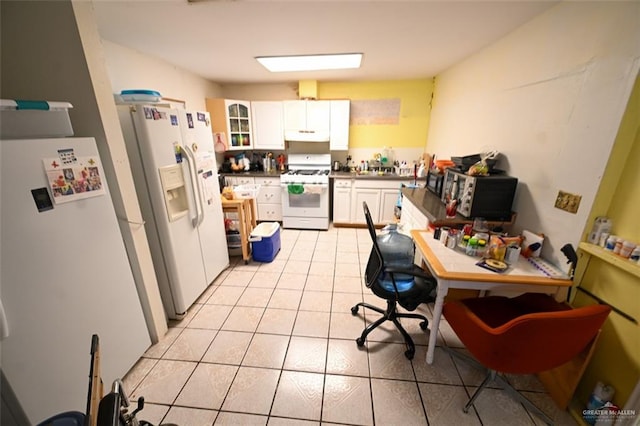 kitchen with white cabinets, light tile patterned flooring, and white appliances