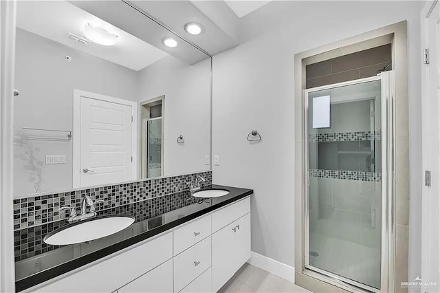 bathroom featuring decorative backsplash, vanity, and an enclosed shower