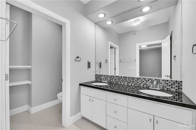 bathroom with tile patterned floors, vanity, toilet, and tasteful backsplash