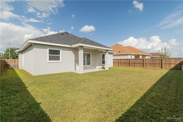 rear view of property featuring a lawn and a patio