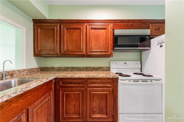 kitchen featuring sink, light stone counters, and white range with electric cooktop