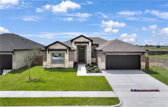 1502 Stirrup Cir, San Benito, TX 78586 - view of front facade with an attached garage, stone siding, concrete driveway, brick siding, and a shingled roof