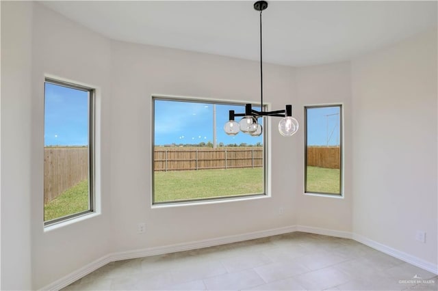 1502 Stirrup Cir, San Benito, TX 78586 - unfurnished dining area featuring a chandelier, plenty of natural light, and baseboards