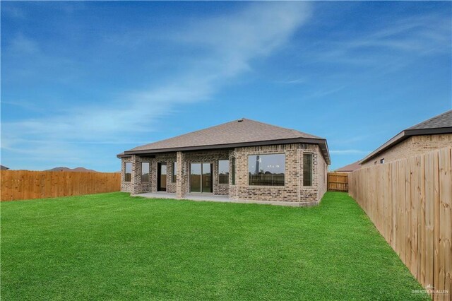 1502 Stirrup Cir, San Benito, TX 78586 - back of property featuring brick siding, a patio, and a shingled roof