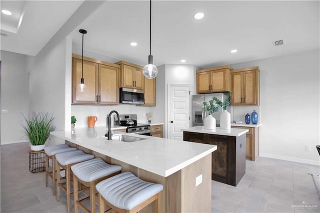 1502 Stirrup Cir, San Benito, TX 78586 - kitchen with appliances with stainless steel finishes, a center island, light countertops, a peninsula, and a breakfast bar area