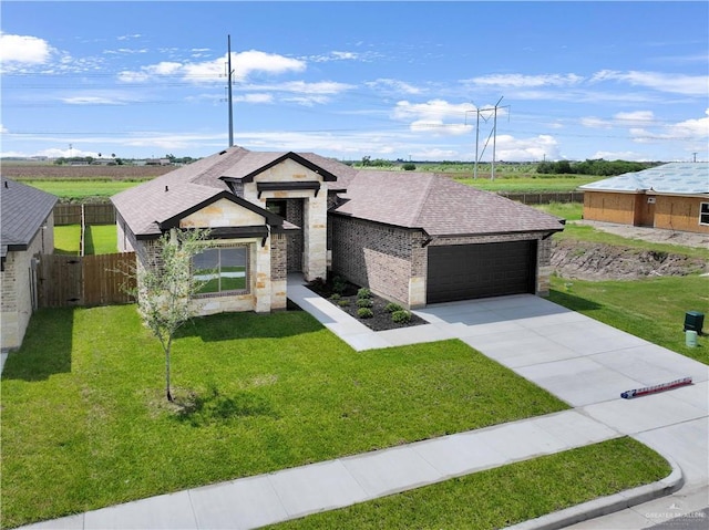 1502 Stirrup Cir, San Benito, TX 78586 - view of front facade featuring a shingled roof, brick siding, stone siding, a garage, and driveway