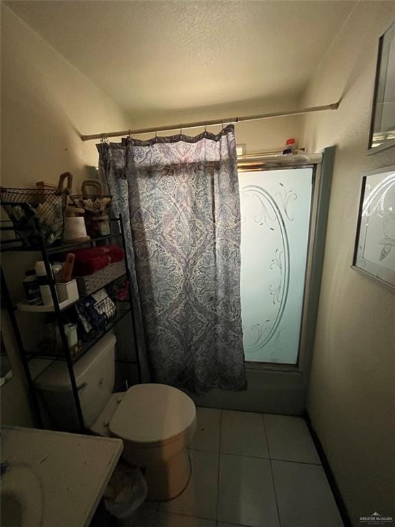 bathroom featuring tile patterned flooring, toilet, and shower / bathtub combination with curtain