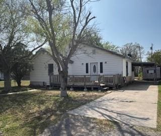 view of front of home featuring a deck, an attached carport, and concrete driveway