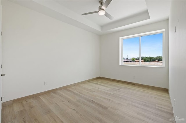 1214 N Lincoln Ave, San Juan, TX 78589 - spare room featuring a tray ceiling, light wood-style flooring, a ceiling fan, and baseboards