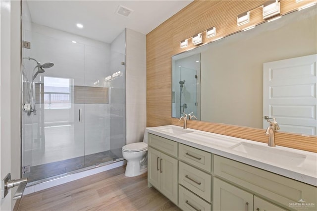 1214 N Lincoln Ave, San Juan, TX 78589 - bathroom with double vanity, a shower stall, toilet, and wood finished floors