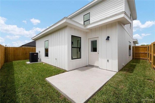3409 Emma Dr, Weslaco, TX 78596 - rear view of house with a yard, a patio, a fenced backyard, board and batten siding, and central AC unit